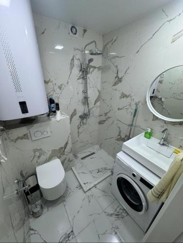 a bathroom with a sink and a washing machine at White Home in K'obulet'i