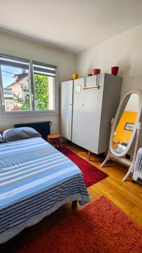 a bedroom with a bed and a large mirror at Chambre dans appartement agréable et calme à 15 mn du Centre Ville in Annecy