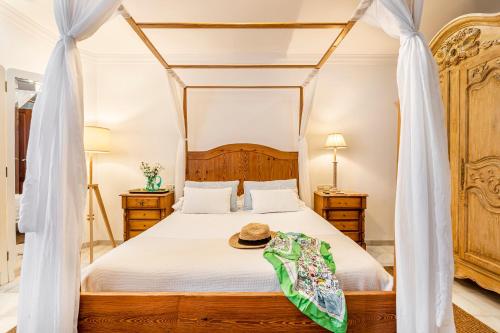 a bedroom with a canopy bed with a hat on it at Casa para familias y grupos in Manises