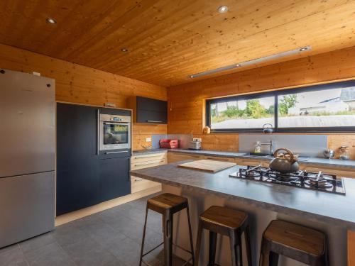 une cuisine avec un grand comptoir et des tabourets. dans l'établissement La Cafoutche X X L, à Gommenec'h