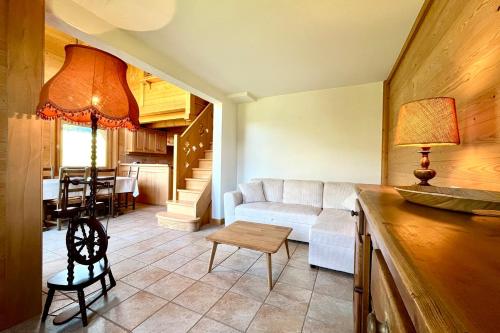 un salon avec un canapé blanc et une table dans l'établissement Apartment with balcony at the gates of Megève, à Combloux