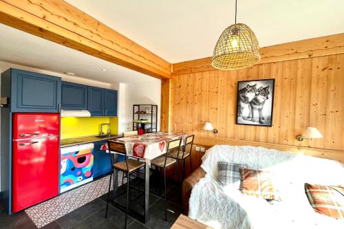 - une cuisine avec des armoires bleues et un réfrigérateur rouge dans l'établissement Superb Cosy Apartment With Balcony, à Combloux