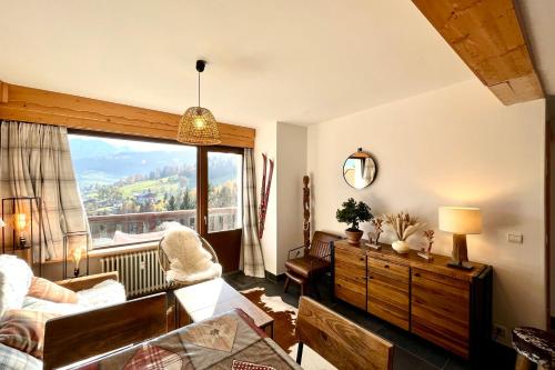 un salon avec une grande fenêtre avec vue dans l'établissement Superb Cosy Apartment With Balcony, à Combloux