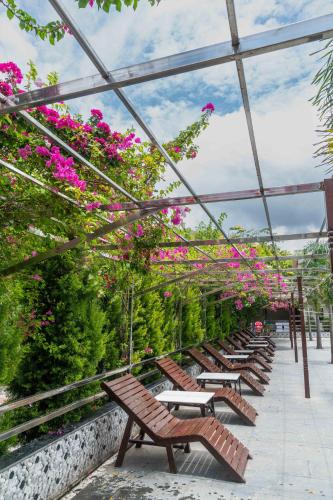 a row of benches with pink flowers in a greenhouse at Hotel Quick Twenty and Riverside Pvt Ltd in Bākhri Kharka