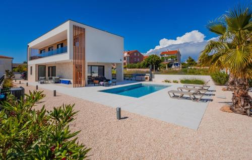 a villa with a swimming pool and a house at Lovely Home In Vodice in Vodice