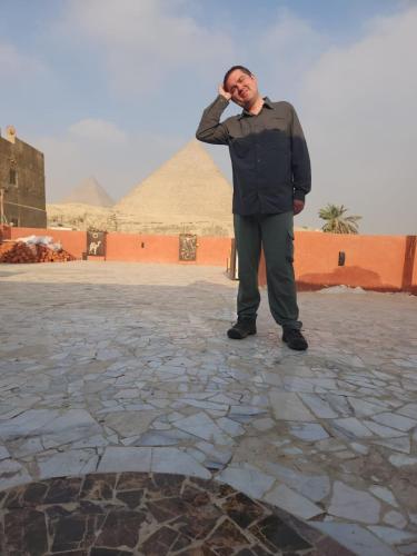a man standing in front of a pyramid at Energy Of Pyramid Hotel in Cairo
