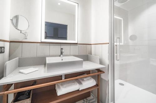 a bathroom with a sink and a mirror and a shower at Villa Arthus-Bertrand in Noirmoutier-en-l'lle