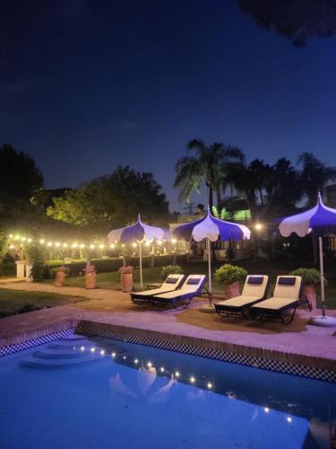 a pool with chairs and umbrellas at night at Casa para familias y grupos in Manises