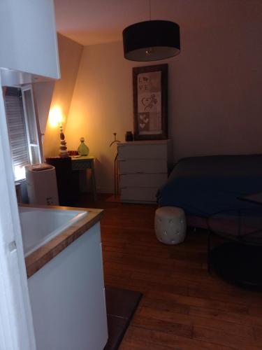 a room with a bed and a kitchen with a table at Studio Neuilly Paris La Défense in Neuilly-sur-Seine