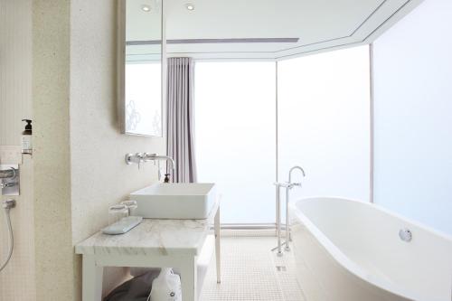 a bathroom with a white tub and a sink at Ambience Hotel Taipei in Taipei