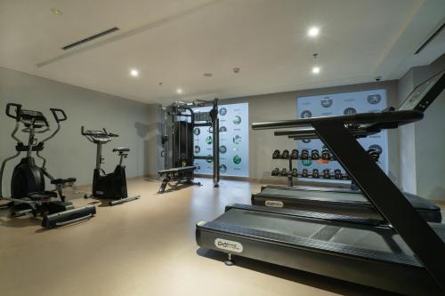 a gym with several treadmills and exercise bikes at Harris Suites Puri Mansion in Jakarta