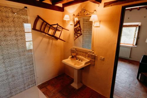 un baño con lavabo y espejo en Vitalenta Agriboutique, en Pienza