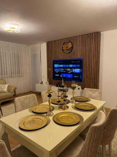 a table with plates on it in a living room at Duplex City Center Gjakove in Gjakove