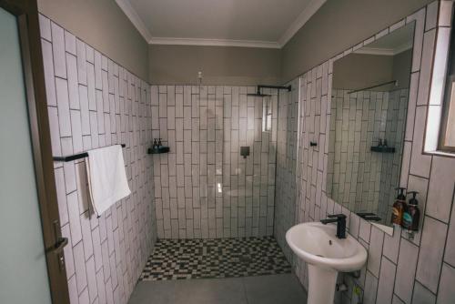 a white bathroom with a sink and a shower at Hammerstein Lodge in Hammerstein