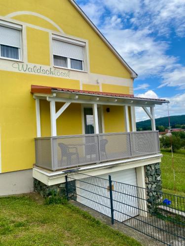 a yellow house with a deck on it at Ferien beim Treiber in Bad Tatzmannsdorf