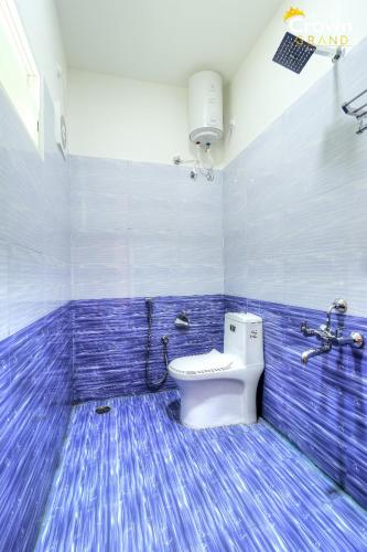 a bathroom with a toilet and a blue tiled floor at Coorg Crown Palace Resort kushalnagar in Jāmb
