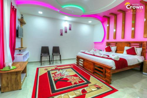 a bedroom with a large bed with pink lighting at Coorg Crown Palace Resort kushalnagar in Jāmb