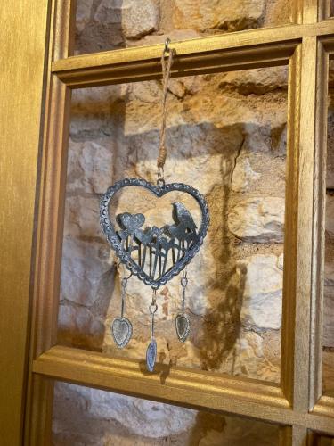 a heart shaped ornament hanging from a stone wall at Les Carillons du Bois de l'Orme in Les Pechs-du-Vers