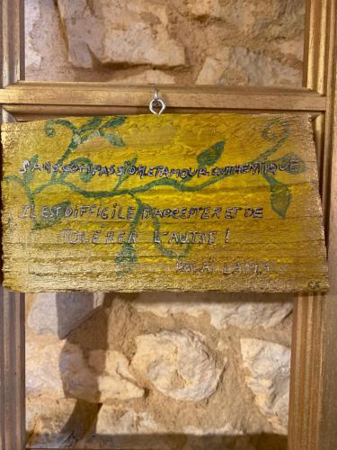 a sign on the side of a stone wall at Les Carillons du Bois de l'Orme in Les Pechs-du-Vers