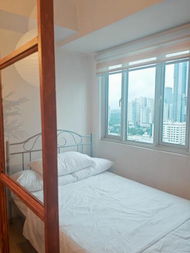 a bedroom with two bunk beds and a window at Spacious studio MPLACE Tower C in Manila