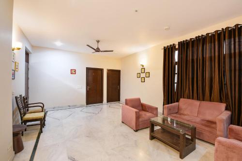 a living room with a couch and chairs and a table at FabHotel Next Home Prime in Gurgaon