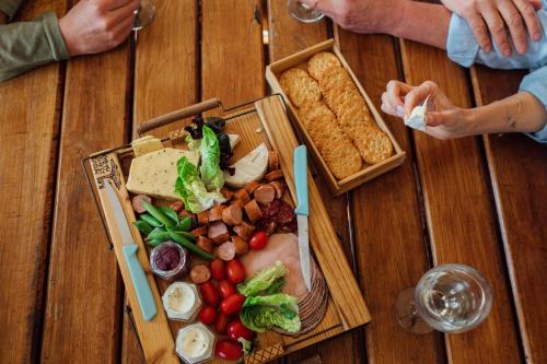 a wooden table with a plate of food on it at Kwetu Guest Farm in Swellendam
