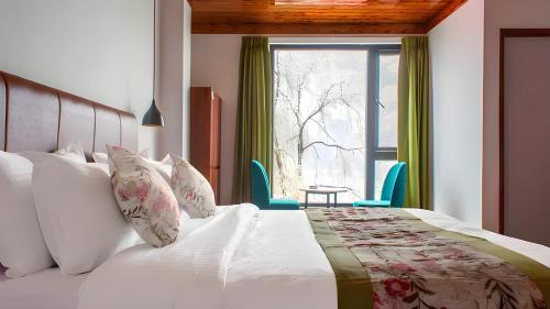 a bedroom with a large bed with a window at Mystique Valley by Trekocity in Lachung