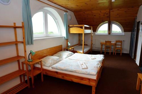 a bedroom with a bed and two bunk beds at Otevřená Náruč Pension in Letovice