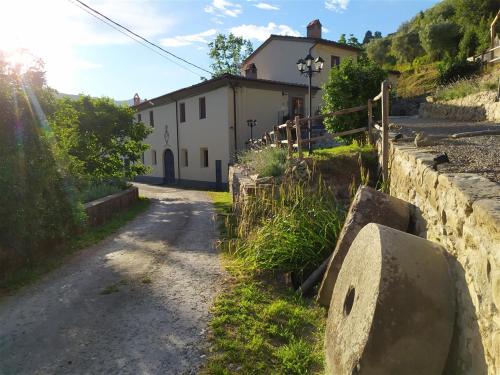a dirt road next to a stone wall with a house at Il Mulino di Celle in Pistoia