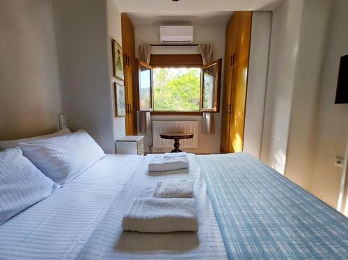 a bedroom with a large bed with towels on it at CENTER o'CLOCK in Xanthi