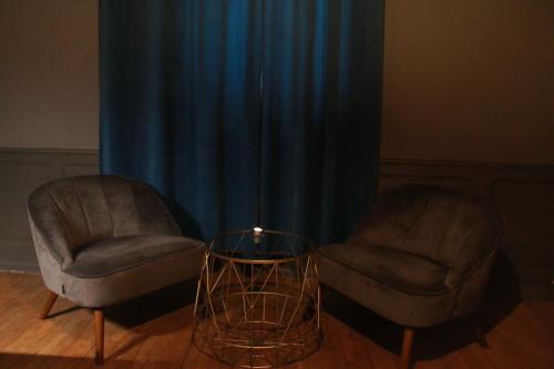 2 chaises et une table devant un rideau dans l'établissement The down town Nenad's SPA, à Dijon