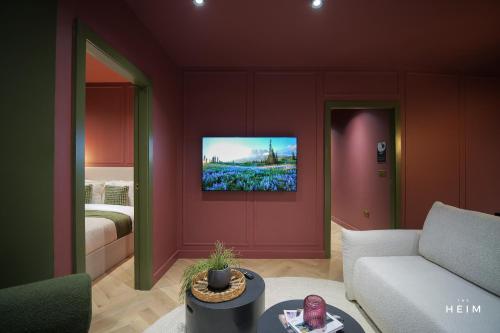 a living room with a couch and a tv on a wall at Malva at The Heim in Manchester