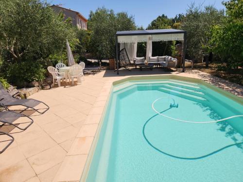 - une piscine dans une cour avec un kiosque dans l'établissement La tranquilité, à Saint-Cézaire-sur-Siagne