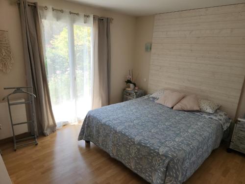 une chambre avec un lit et une grande fenêtre dans l'établissement La tranquilité, à Saint-Cézaire-sur-Siagne