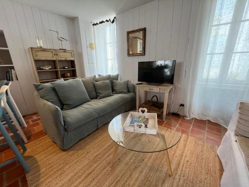 a living room with a couch and a coffee table at La Maison de la Forge pour 4 personnes in Saint-Clément-des-Baleines