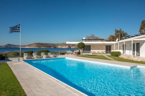 a swimming pool in the backyard of a house at Paradise Beachfront Villa Athenian Riviera in Aghia Marina