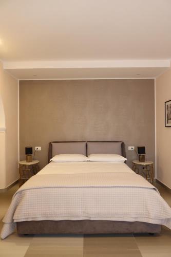 a bedroom with a large bed with two side tables at La Corte dei Sabatini in Pietrapaola
