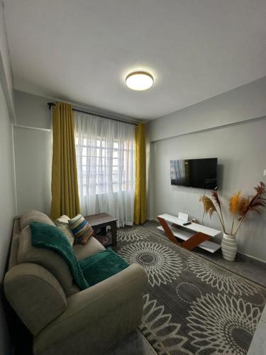ein Wohnzimmer mit Sofa und Fernseher in der Unterkunft Akombe homestay-Makasembo in Kisumu