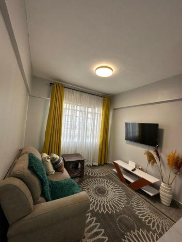 ein Wohnzimmer mit Couch und Flachbildfernseher in der Unterkunft Akombe homestay-Makasembo in Kisumu