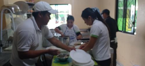 a group of people in a kitchen preparing food at Green House Araque Inn in Otavalo