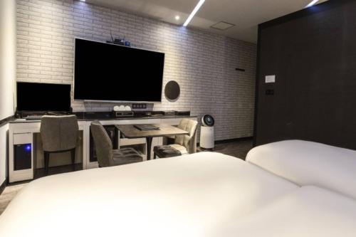 a bedroom with a bed and a desk with a television at 3S HOTEL 동탄점 - Boutique in Hwaseong