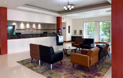 a waiting room with chairs and a bar at SureStay by Best Western Irving Grapevine DFW North in Irving
