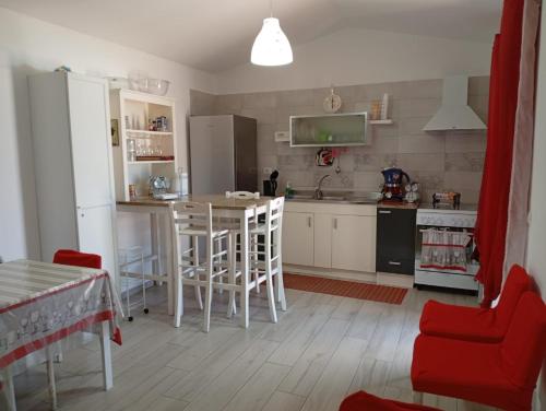 eine Küche mit Tisch und Stühlen und einem Kühlschrank in der Unterkunft La Maison di Sara in Santa Maria La Carità