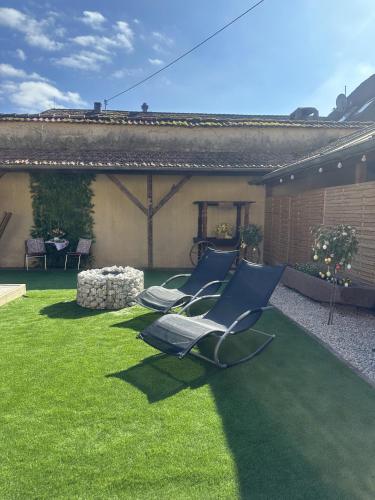 two lounge chairs on a lawn in a yard at Hotel Eulenhof in Gransdorf