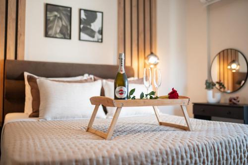 a bottle of wine on a table on a bed at Athenee in Preveza