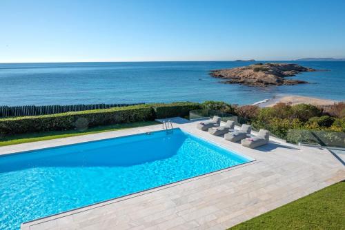 a swimming pool with a view of the ocean at Paradise Beachfront Villa Athenian Riviera in Aghia Marina
