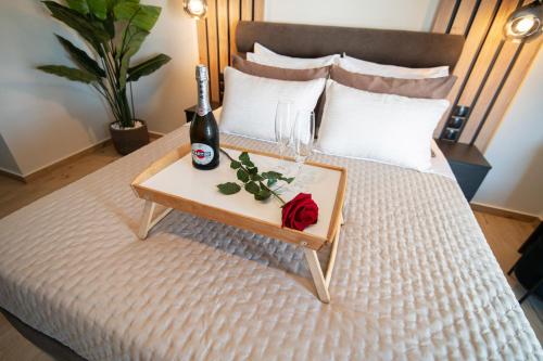 a bed with a bottle of wine and a table with a bottle of champagne at Athenee in Preveza