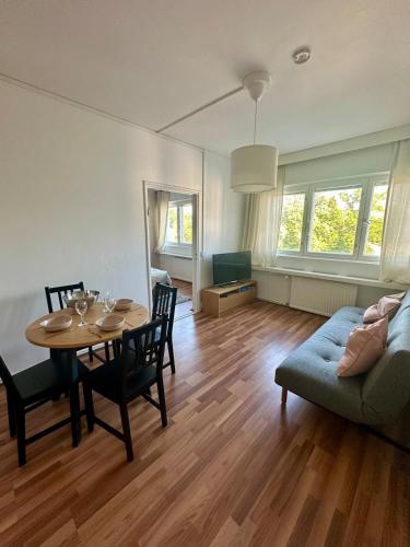 una sala de estar con una mesa y un sofá en Stylish 2 Bed Central Apartment with Park View, en Turku