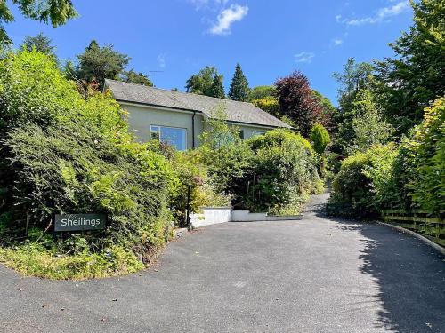 a house with a driveway and some bushes at Sheilings in Elterwater