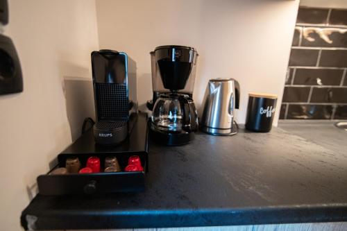 a counter with a coffee maker and a box of red peppers at Athenee in Preveza